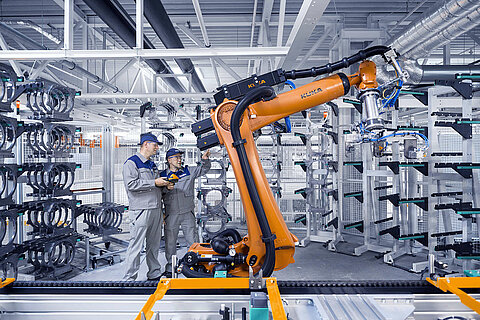 Zwei Leadec-Mitarbeiter bei der Wartung eines Roboters in der Produktion.